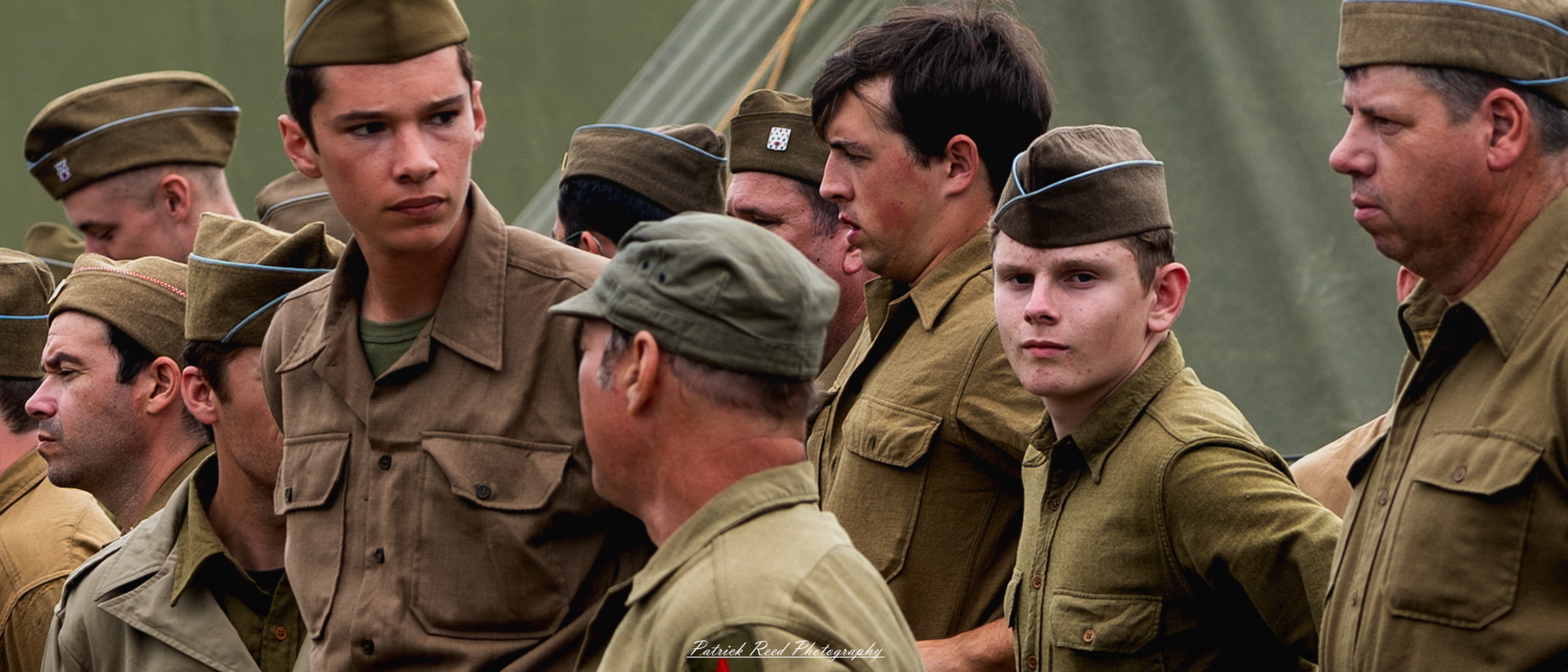 Soldiers in formation, engaging in quiet conversation while maintaining their disciplined stance. The scene captures a moment of camaraderie and communication within the structured environment of military life, reflecting both unity and readiness.
